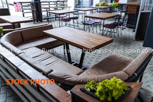 Summer cafe empty table no guests, lounge area for restaurant visitors on the street, interior of the bar, soft sofa for sitting. loft style.