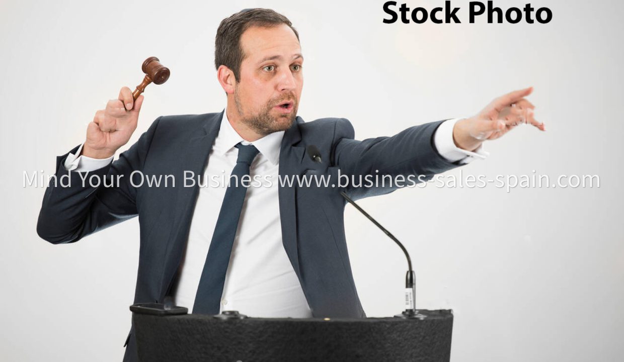 a-male-auctioneer-in-action-holing-a-gavel-during-a-live-auction-HN4X1Y