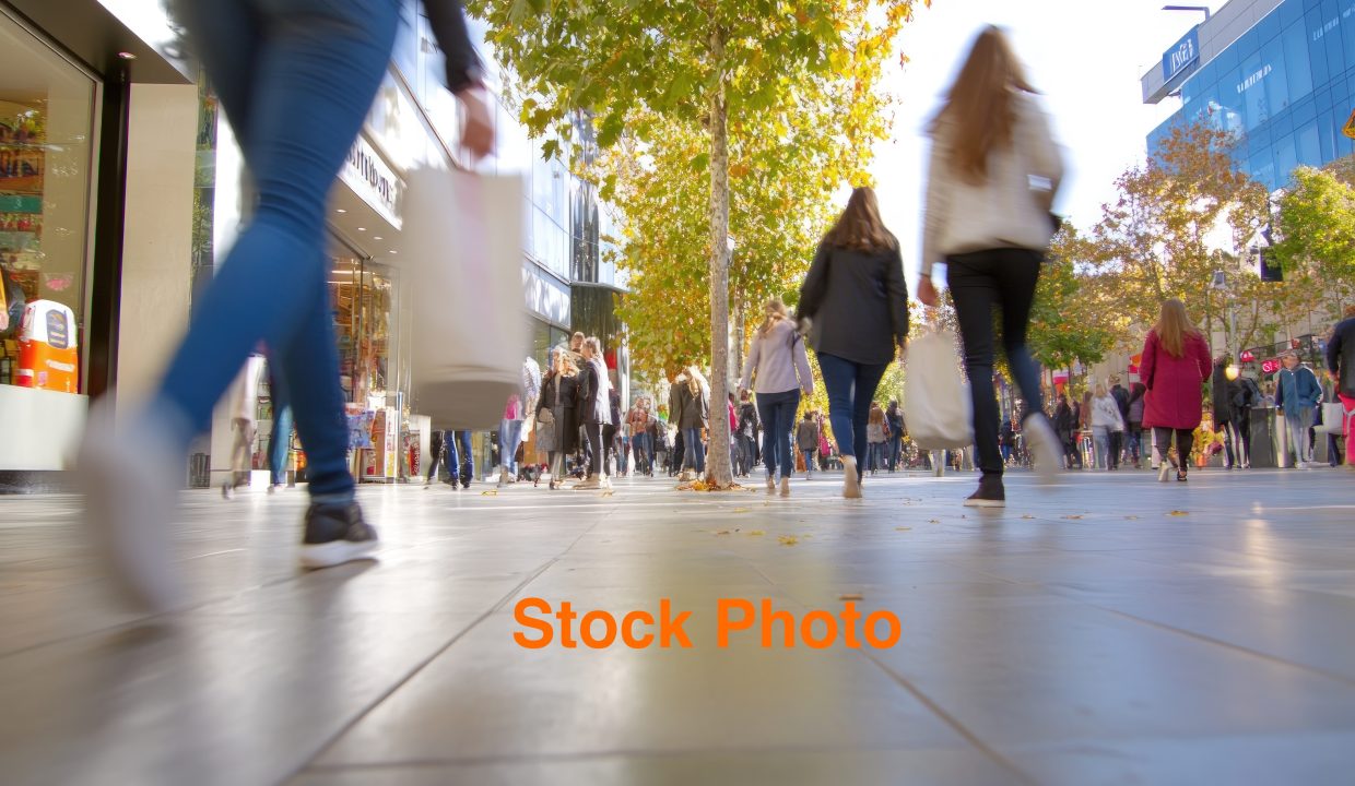 People walking in city street on sunny day crowded urban scene